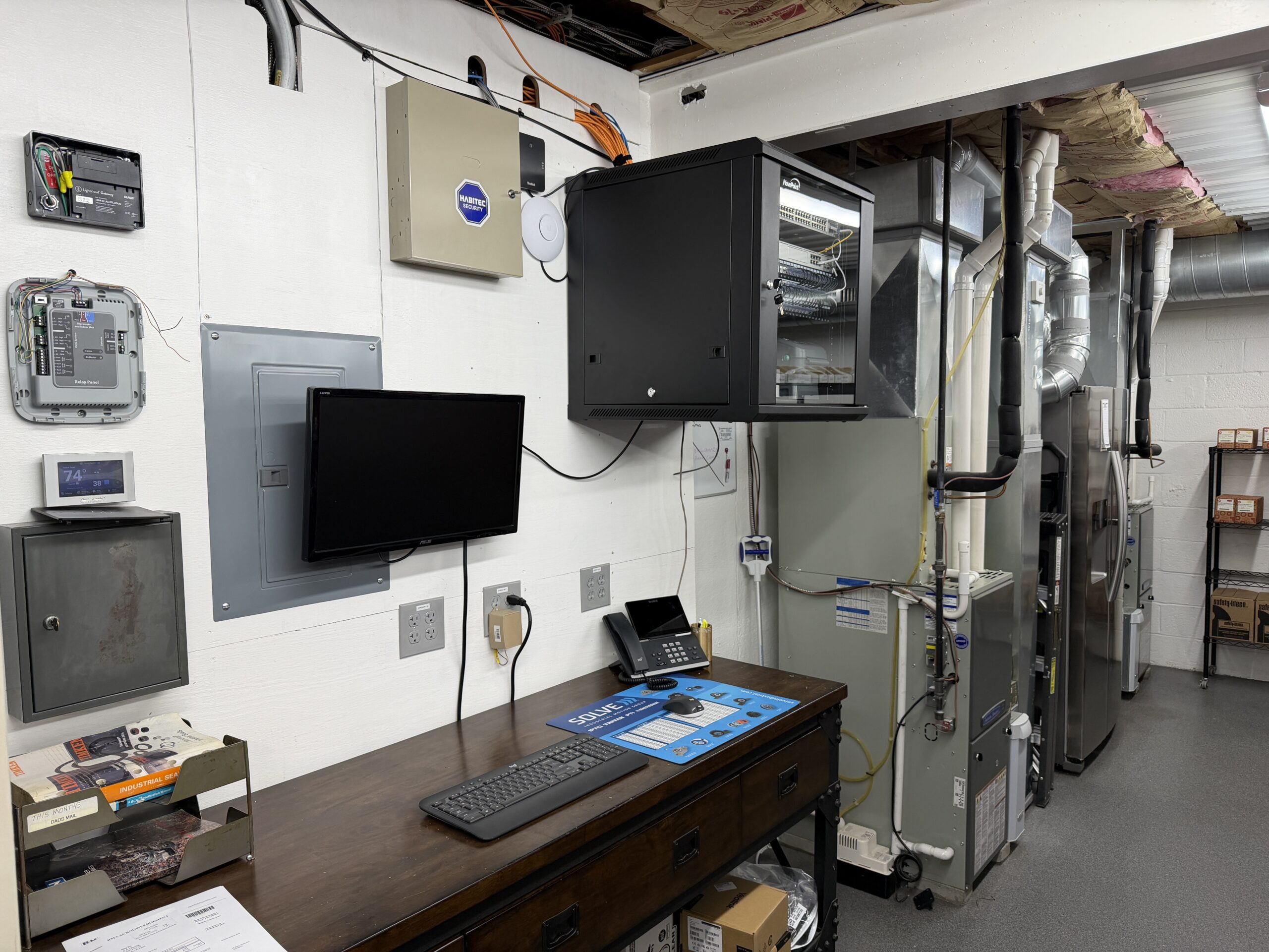 After — wall-mount rack enclosure with patch panels, managed switch, clean cable trays, Ubiquiti AP